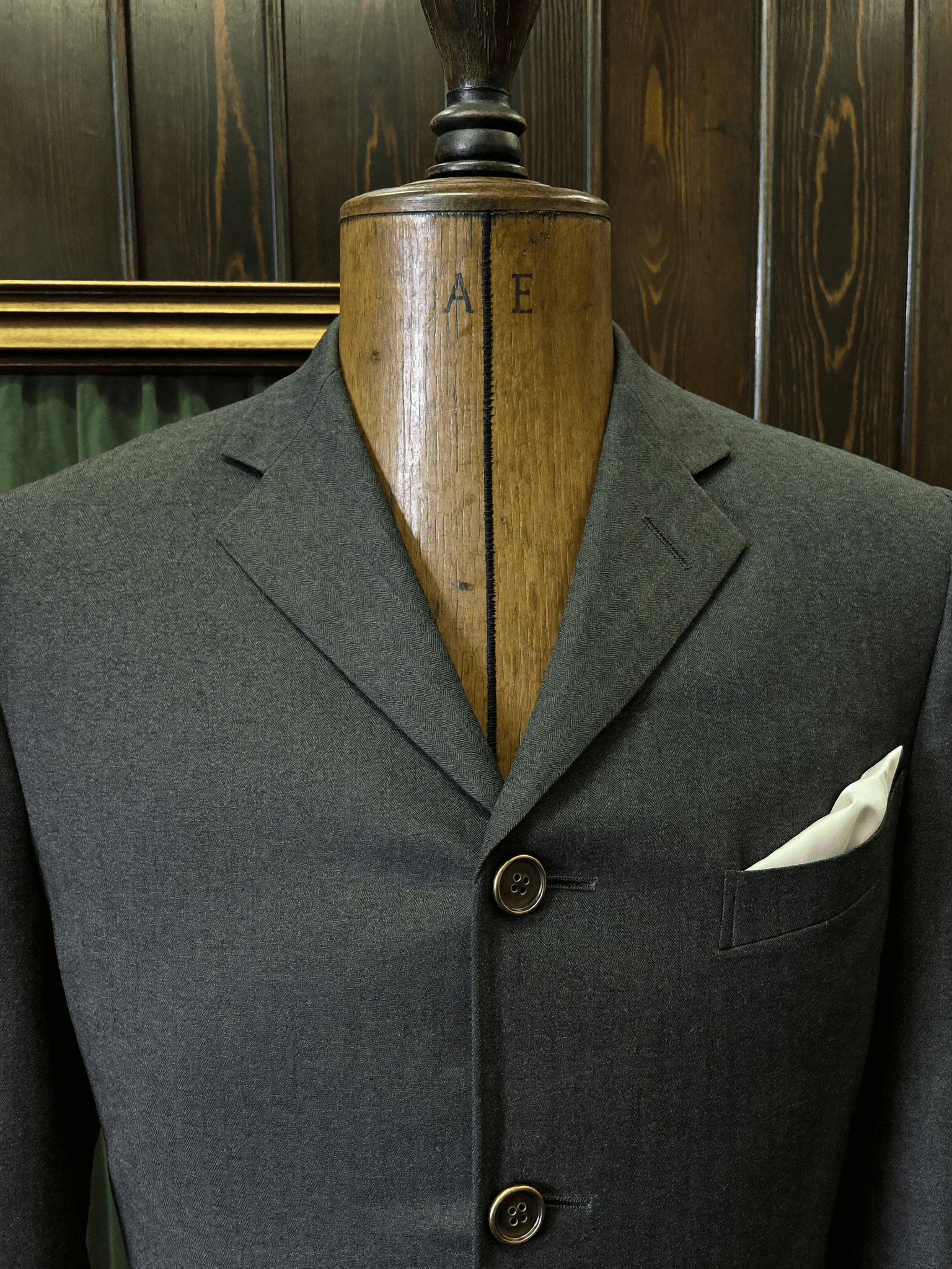 Detalle de un traje bespoke terminado en maniquí de madera